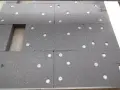 Panneau de polystyrène gris avec des fixations blanches. On compte 3 à 4 chevilles par plaque de polystyrène pour l'isolation.