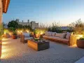 Terrasse moderne avec mobilier de jardin, plantes et éclairage d'ambiance sur un sol en gravier. Le prix du gravier m3 est un détail à considérer pour un tel aménagement.
