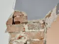 Fissures dans un mur de briques, signe d'une **stabilisation fondation maison sol argileux** nécessaire.