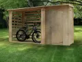 Un abri en bois pour fabriquer abri vélo, avec deux vélos à l'intérieur. La structure ouverte protège les vélos des intempéries.