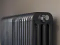 Gros plan sur un radiateur bain d'huile noir, avec un bouchon chromé visible. Un élément clé pour gérer la consommation d'énergie.