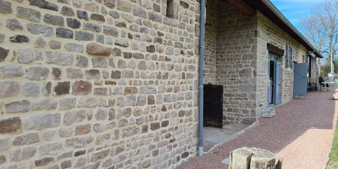 Mur en pierre avec un mortier de couleur joint clair, typique d'une rénovation de bâtisse ancienne.