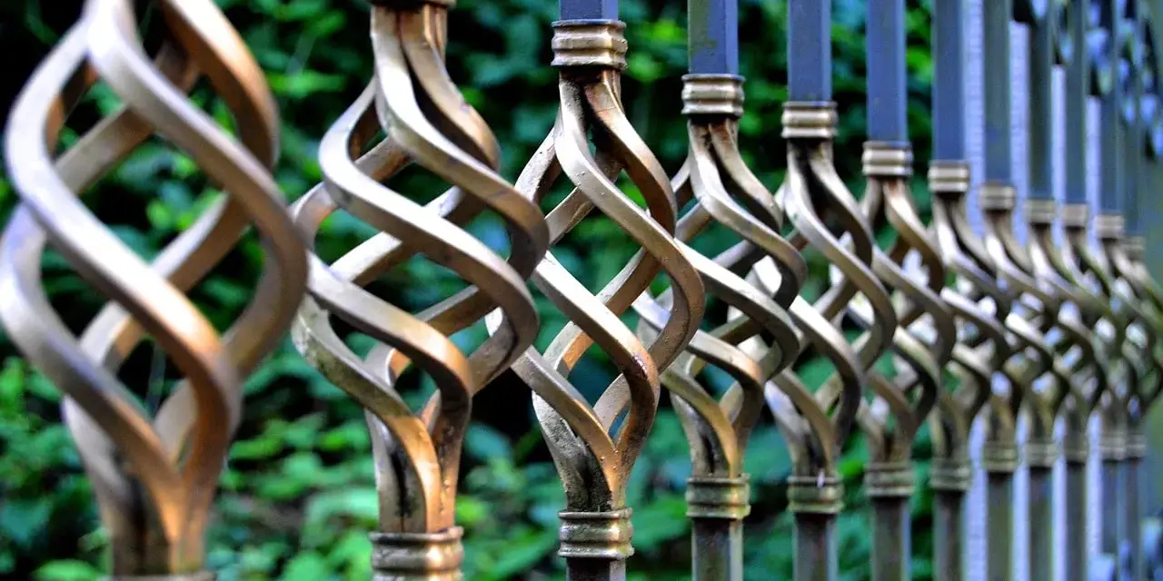 Barreaux de fer forgé torsadés, prêts à être nettoyés avant peinture. Le métal patiné attend une nouvelle vie.