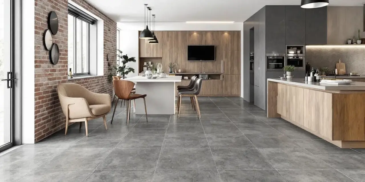 Carrelage pièce de vie tendance, un salon-cuisine moderne avec mur en briques apparentes, îlot central et mobilier en bois.
