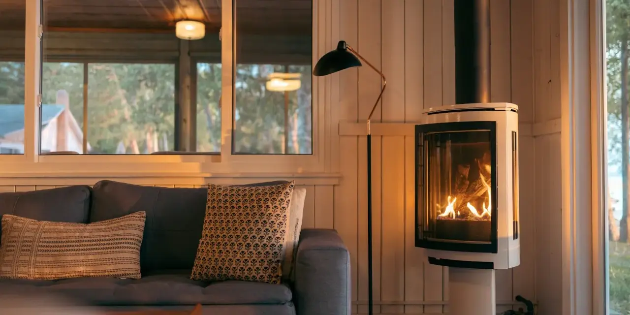 Un poêle à bois moderne, avec un feu vif, est placé à distance du mur en placo, créant une ambiance chaleureuse.
