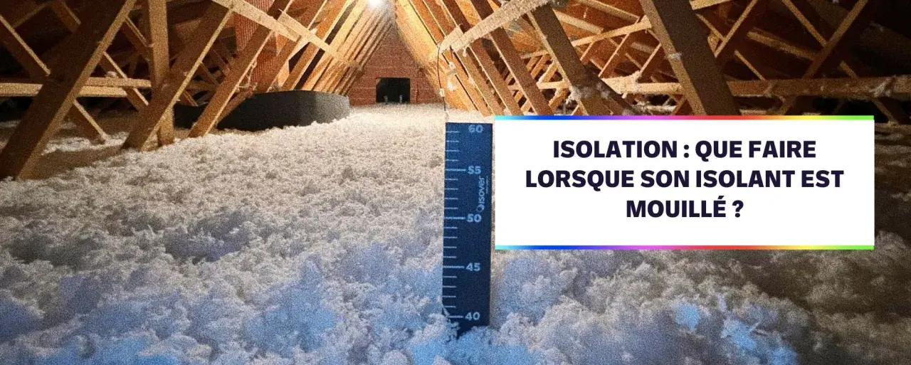 Isolation d'un grenier avec de la laine de coton. Une règle mesure l'épaisseur de l'isolant.