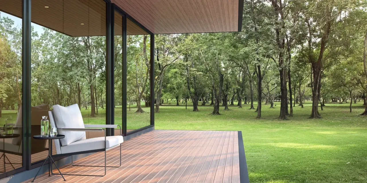 Une terrasse moderne avec un revêtement de terrasse en résine, offrant une vue paisible sur une forêt verdoyante. Un fauteuil confortable invite à la détente.