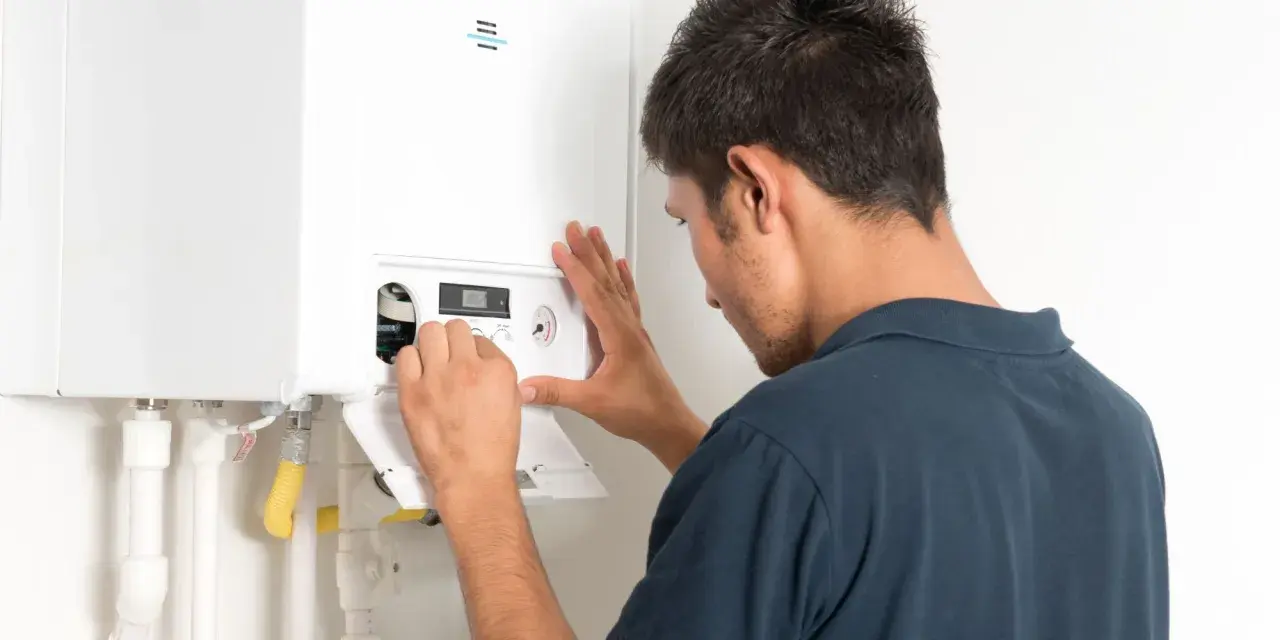 Un technicien ajuste une chaudière à condensation. L'installation est en cours, assurant un chauffage efficace.