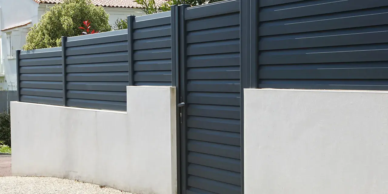 Devis mur de clôture en parpaing : mur bas en béton avec portail gris anthracite et claustras modernes.
