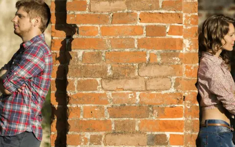 Un homme et une femme se tournent le dos, appuyés contre un mur de briques. Peut-on fixer quelque chose sur un mur mitoyen ?