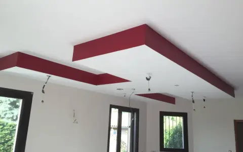 Plafond moderne avec caisson décoratif rouge et emplacements pour spots.