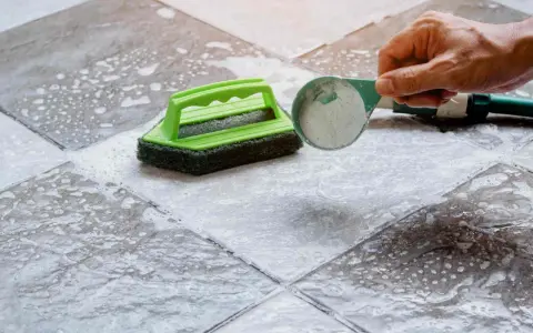 Nettoyer carrelage extérieur antidérapant avec une brosse et une poudre nettoyante.
