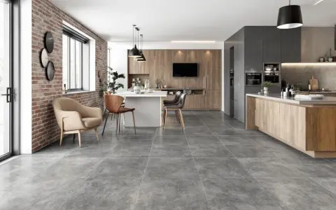 Carrelage pièce de vie tendance, un salon-cuisine moderne avec mur en briques apparentes, îlot central et mobilier en bois.
