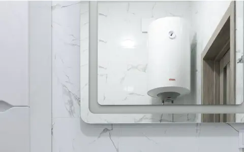 Gros chauffe-eau blanc, une chaudière micro accumulation, reflété dans un grand miroir, sur fond de carrelage marbré.