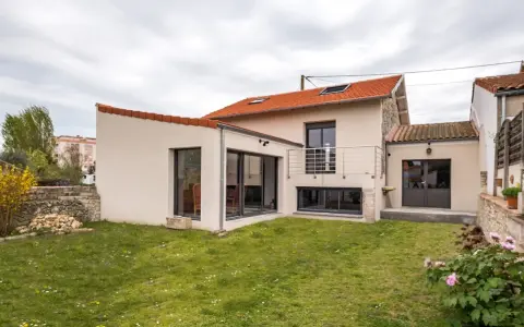 Maison avec extension moderne, jardin verdoyant. Le prix d'une extension maison 20m2 peut varier, mais ce type d'agrandissement offre un espace de vie supplémentaire.