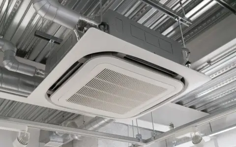 Unité de climatisation par le plafond, discrète et efficace, intégrée dans un faux plafond avec des conduits d'air apparents.