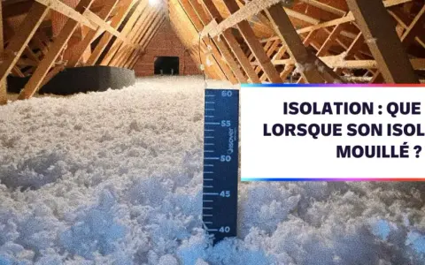 Isolation d'un grenier avec de la laine de coton. Une règle mesure l'épaisseur de l'isolant.