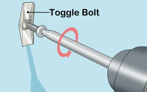Utilisation d'un boulon à bascule pour accrocher un miroir au mur. La vis est insérée dans le mur et le mécanisme à bascule s'ouvre derrière la cloison sèche.