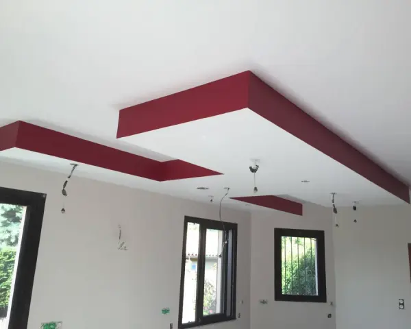 Plafond moderne avec caisson décoratif rouge et emplacements pour spots.