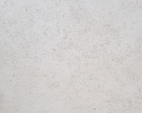 Surface texturée d'enduit chaux chanvre finition lisse, d'une teinte claire et naturelle, évoquant la douceur d'un mur sain.