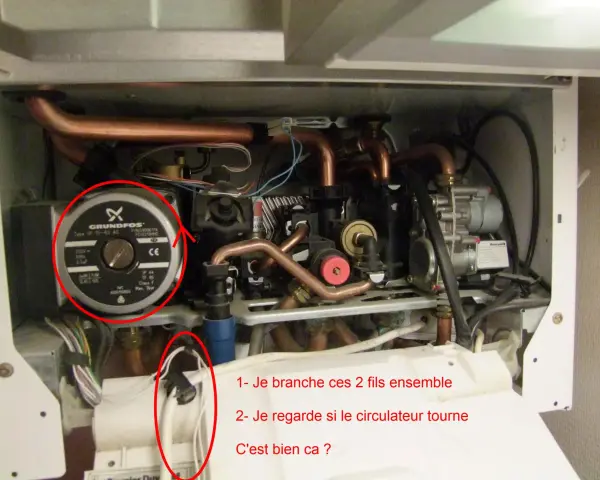 Intérieur d'une chaudière, avec une pompe Grundfos et des tuyaux de cuivre. Des fils sont entourés, suggérant une réparation pour un problème de chaudière ne se déclenche pas eau chaude.