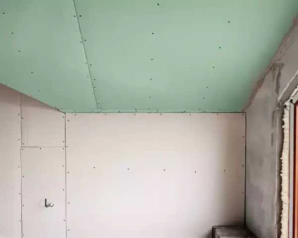 Jonction mur plafond placo, avec un plafond vert et des murs blancs. Travaux de rénovation en cours.