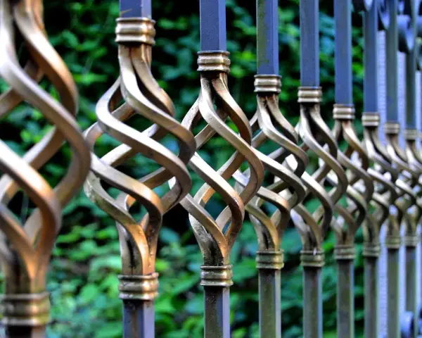 Barreaux de fer forgé torsadés, prêts à être nettoyés avant peinture. Le métal patiné attend une nouvelle vie.