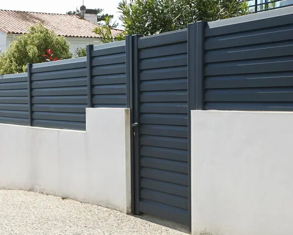 Devis mur de clôture en parpaing : mur bas en béton avec portail gris anthracite et claustras modernes.
