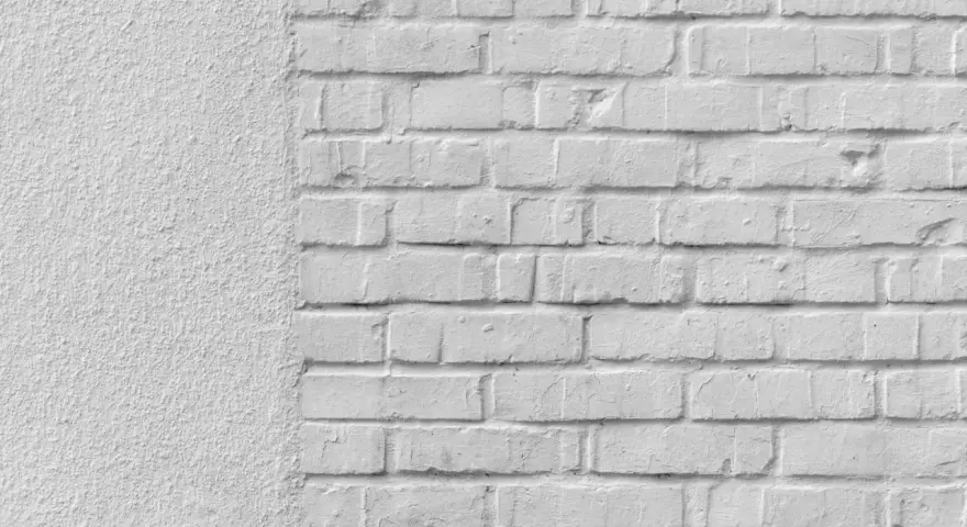 Mur blanc texturé à gauche, briques blanches à droite. Idéal pour un devis de prix piquage et rejointoiement.