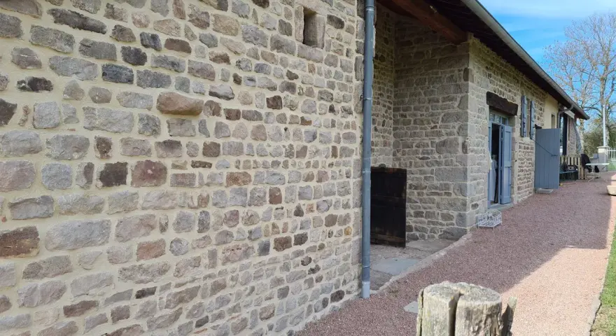 Mur en pierre avec un mortier de couleur joint clair, typique d'une rénovation de bâtisse ancienne.