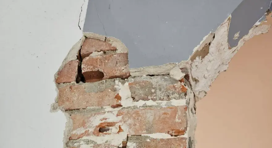 Fissures dans un mur de briques, signe d'une **stabilisation fondation maison sol argileux** nécessaire.