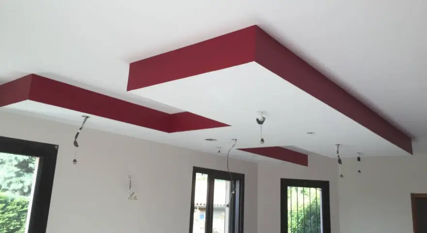 Plafond moderne avec caisson décoratif rouge et emplacements pour spots.