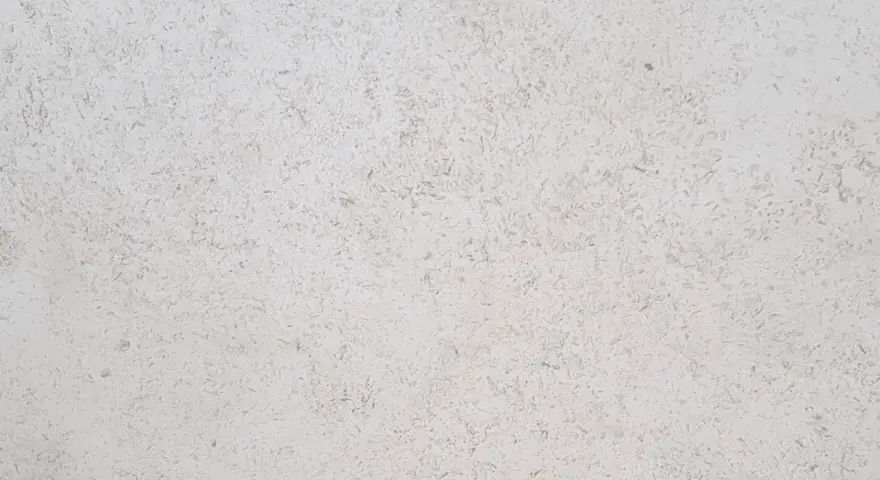 Surface texturée d'enduit chaux chanvre finition lisse, d'une teinte claire et naturelle, évoquant la douceur d'un mur sain.