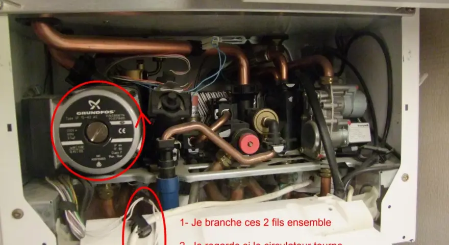 Intérieur d'une chaudière, avec une pompe Grundfos et des tuyaux de cuivre. Des fils sont entourés, suggérant une réparation pour un problème de chaudière ne se déclenche pas eau chaude.