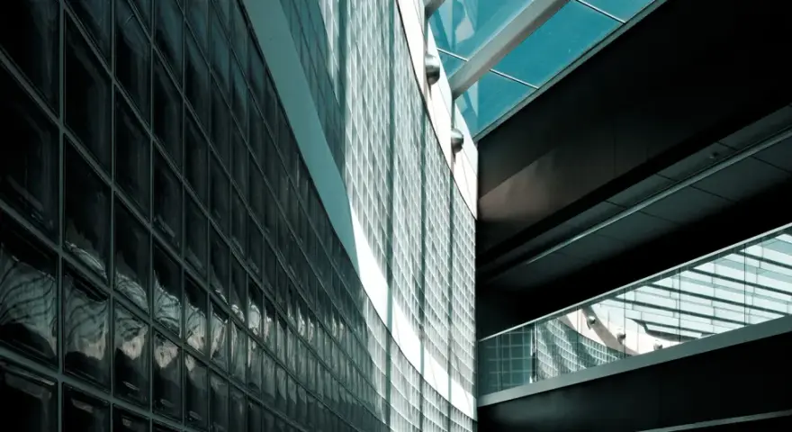 Mur extérieur en pose brique de verre, reflétant la lumière et créant des jeux d'ombres sur la façade moderne.