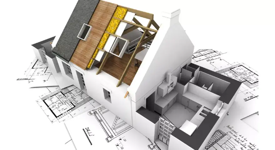 Maquette d'une maison en cours de rénovation, montrant la structure du toit et l'intérieur, posée sur des plans d'architecte. Un projet pour réhabiliter une maison.