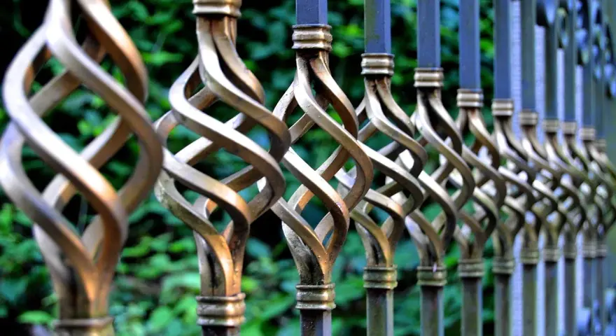 Barreaux de fer forgé torsadés, prêts à être nettoyés avant peinture. Le métal patiné attend une nouvelle vie.