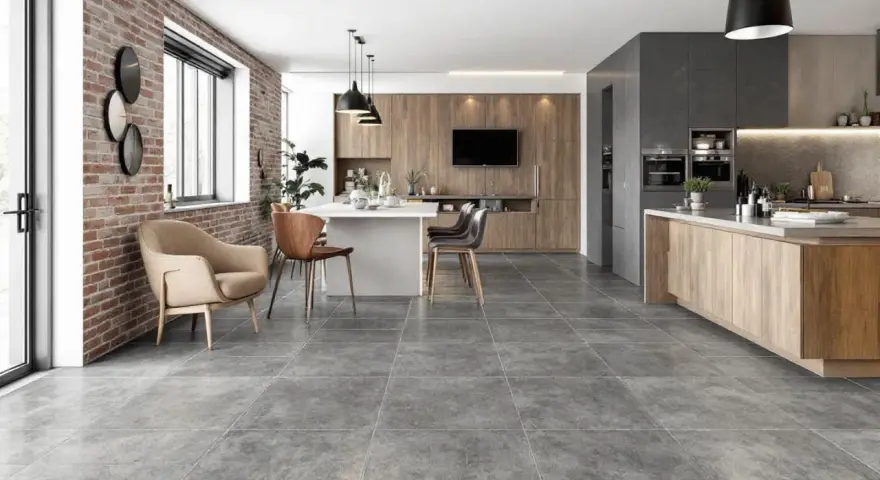 Carrelage pièce de vie tendance, un salon-cuisine moderne avec mur en briques apparentes, îlot central et mobilier en bois.