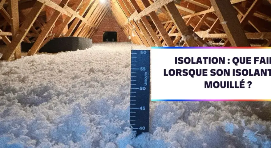 Isolation d'un grenier avec de la laine de coton. Une règle mesure l'épaisseur de l'isolant.