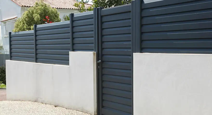 Devis mur de clôture en parpaing : mur bas en béton avec portail gris anthracite et claustras modernes.