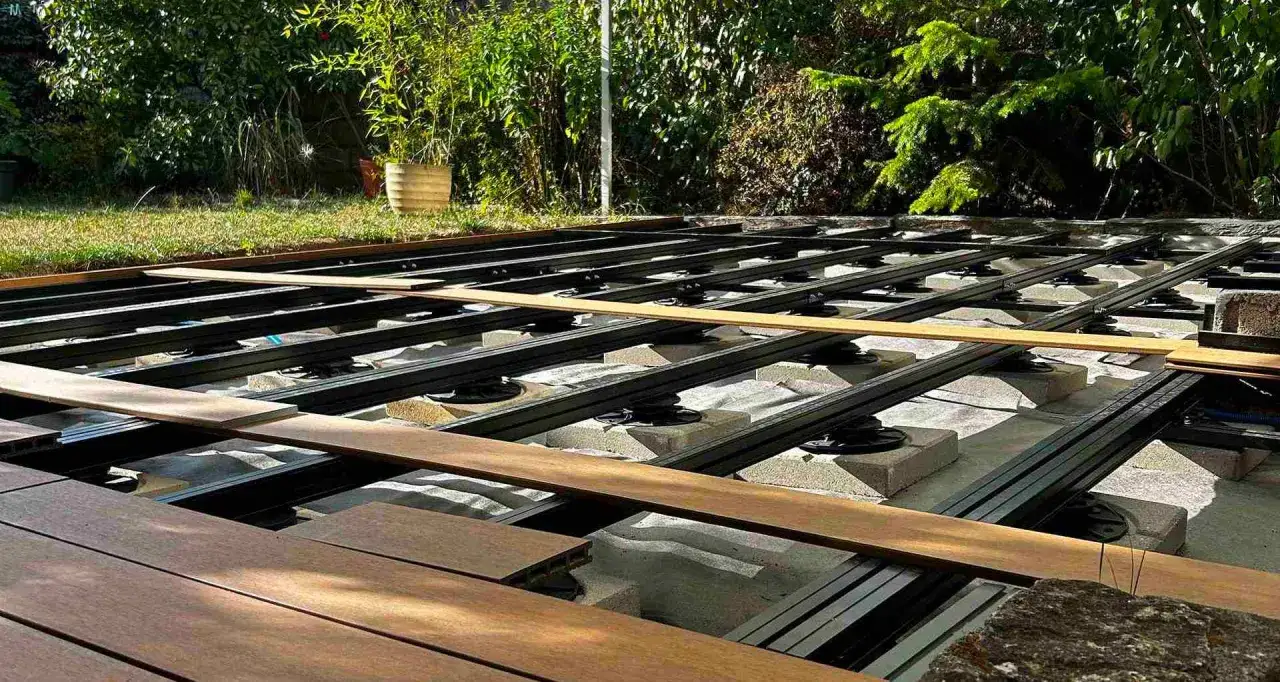 Construction d'une terrasse en bois sur plot. La structure m&eacute;tallique est pos&eacute;e sur des supports r&eacute;glables, pr&ecirc;te &agrave; accueillir les lames de bois.