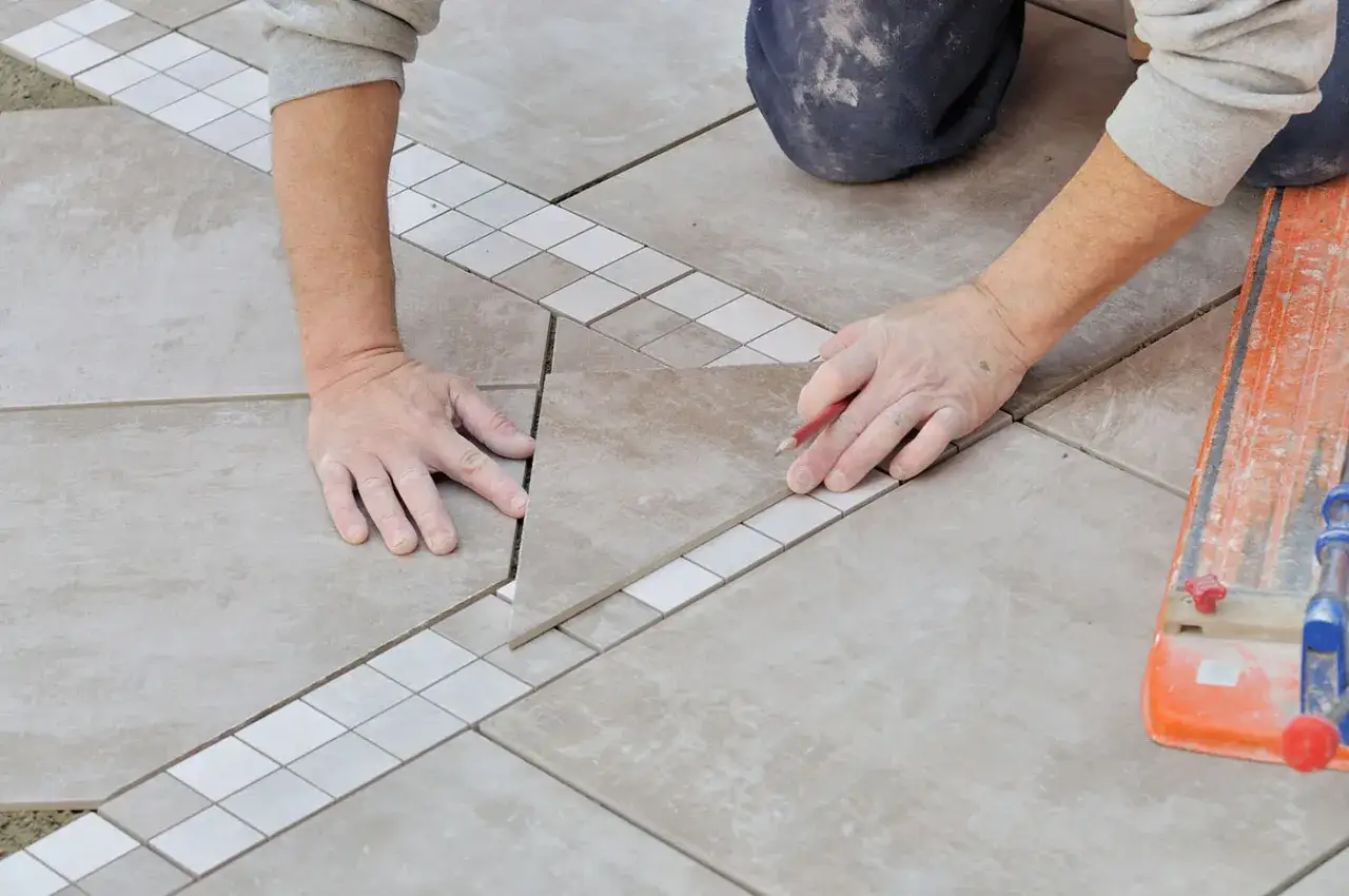 Pose de carrelage extérieur avec une bordure décorative. Le prix pose carrelage m2 dépend de la complexité du motif.