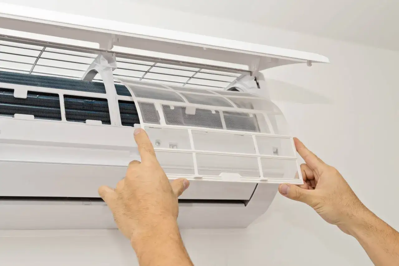 Nettoyage du filtre de climatiseur. Une cause fréquente pour laquelle la clim s'arrête et redémarre est un filtre encrassé.