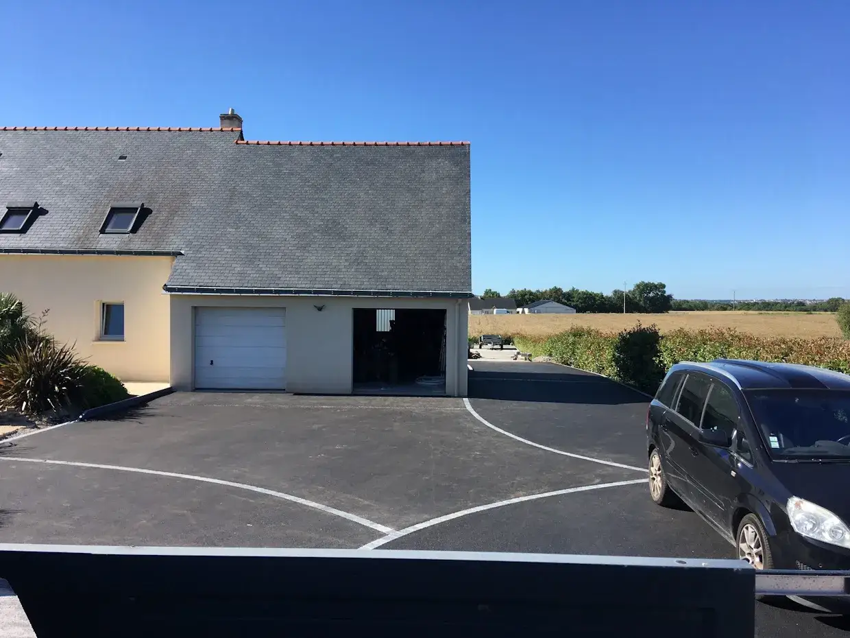 Allée enrobée devant une maison avec garage. Le prix au m2 enrobé pour un particulier est un investissement pour un accès durable.