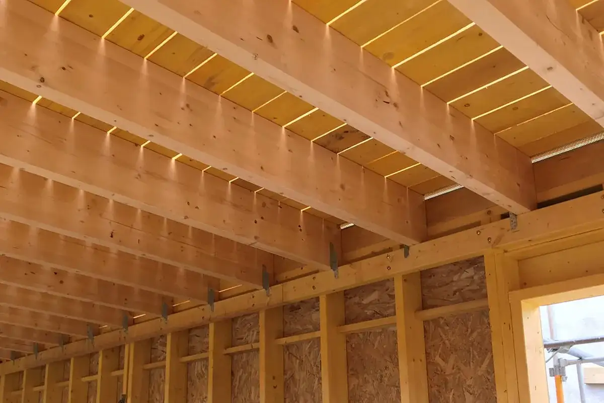 Structure en bois avec solives apparentes, éclairées par le dessus. Idéal pour estimer le prix solivage plancher m2.