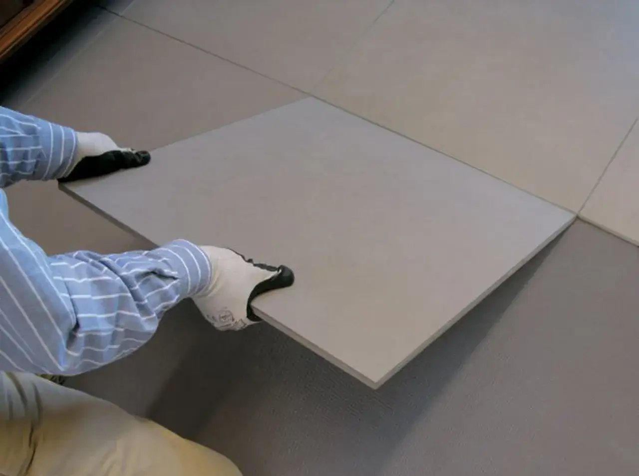 Pose d'une nouvelle dalle pour coller du carrelage sur du carrelage existant.