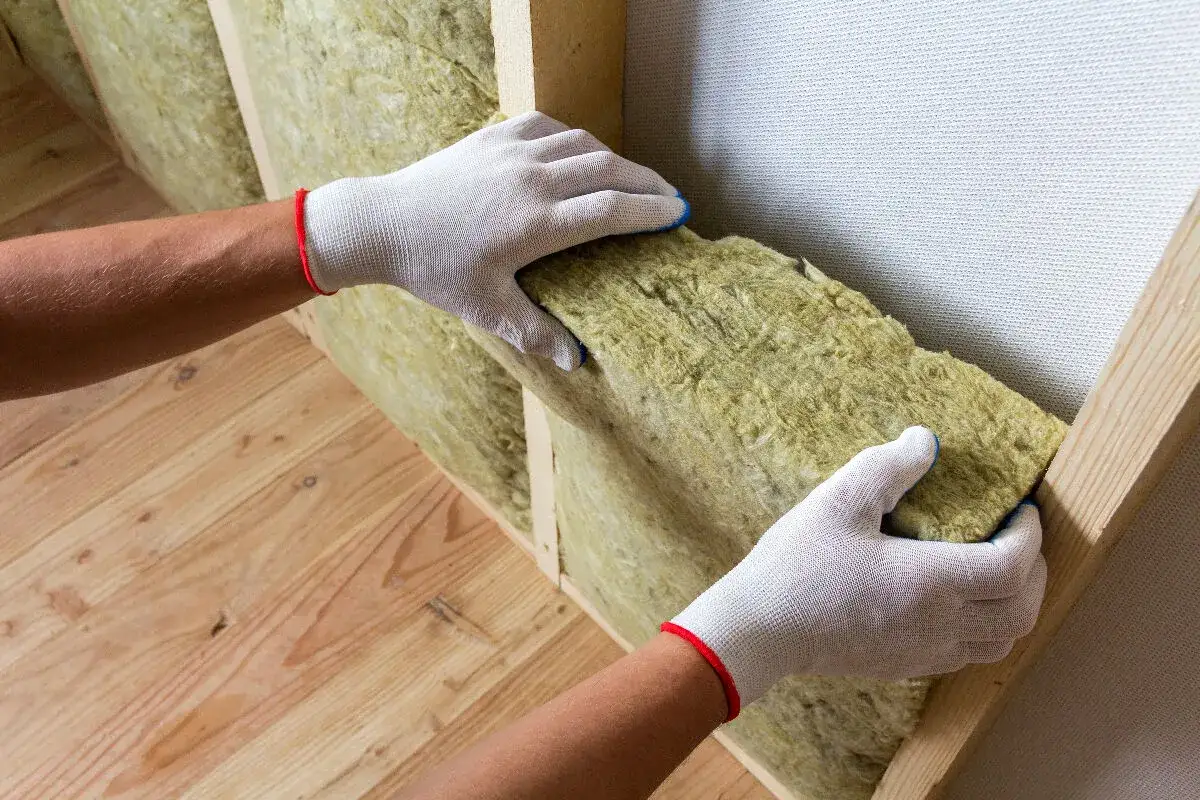 Pose d'un isolant en laine de roche, le meilleur isolant thermique pour une maison confortable.