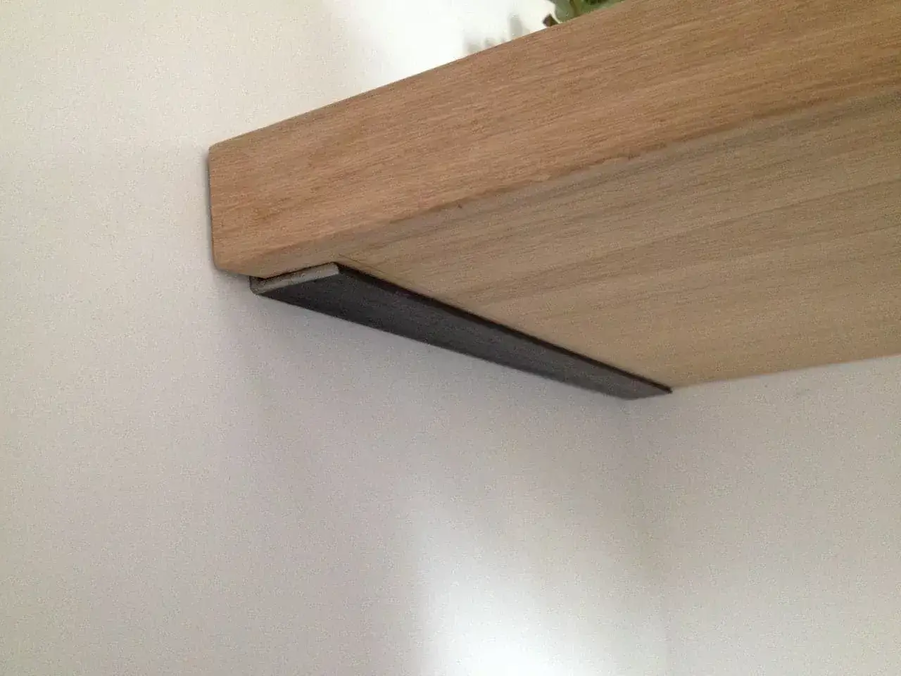 Fixer etagere placo : une &eacute;querre m&eacute;tallique discr&egrave;te soutient une &eacute;tag&egrave;re en bois clair contre un mur blanc.