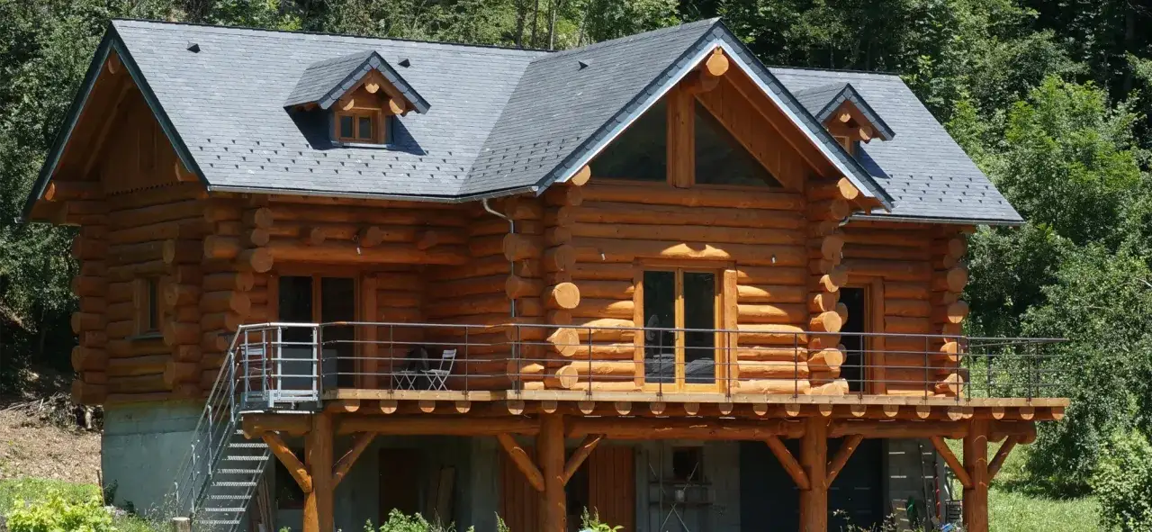 Magnifique maison en rondin de bois nichée dans la verdure. Une terrasse en bois entoure cette demeure chaleureuse.