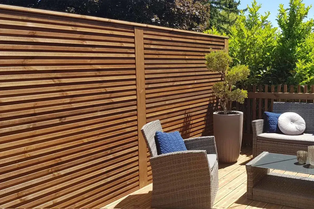 Clôture anti bruit en bois, créant un espace détente sur la terrasse avec mobilier extérieur et végétation.